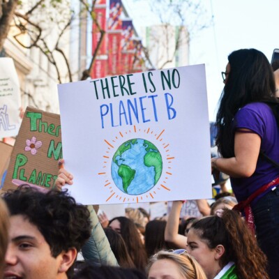 Demonstrationszug, im Fokus ein Plakat mit der Aufschrift "There is no Planet B" mit einer Erde abgebildet